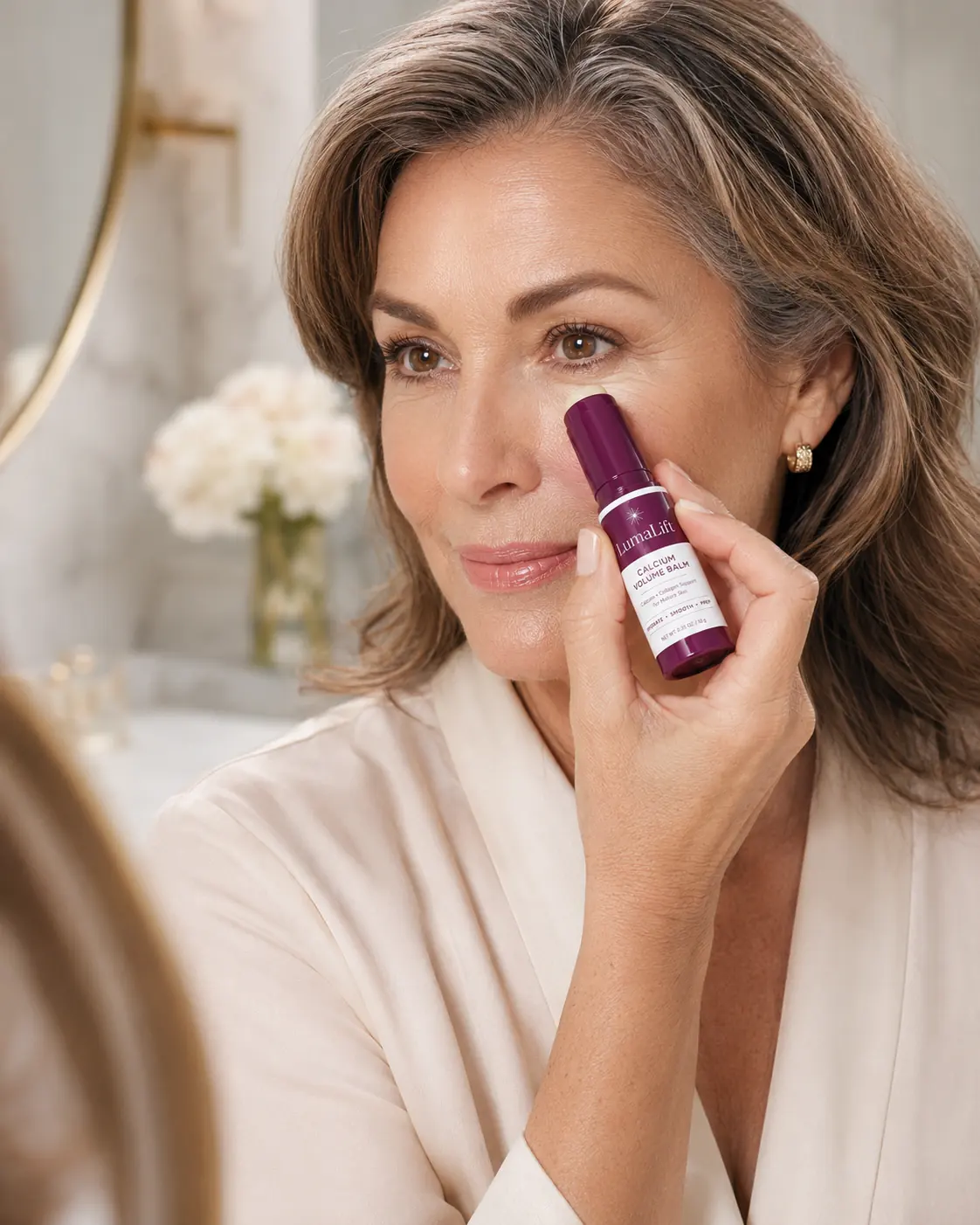 Mature woman applying LumaLift balm under the eyes